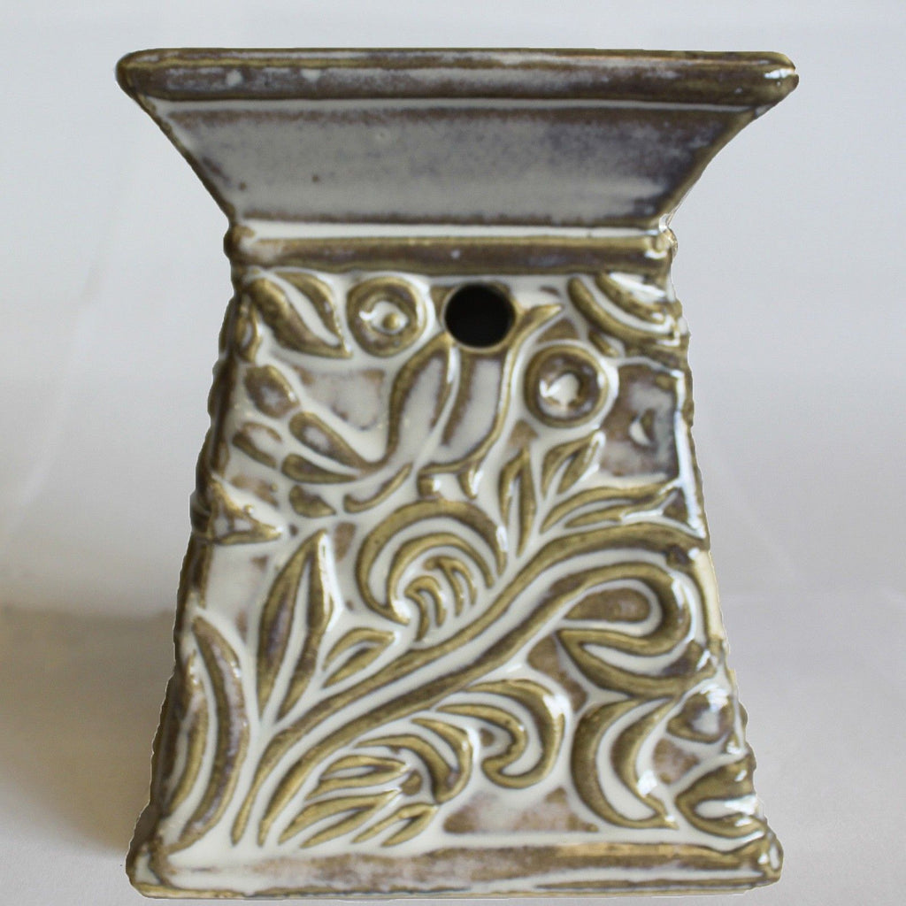 Decorative ceramic oil burner with intricate patterns on a white background