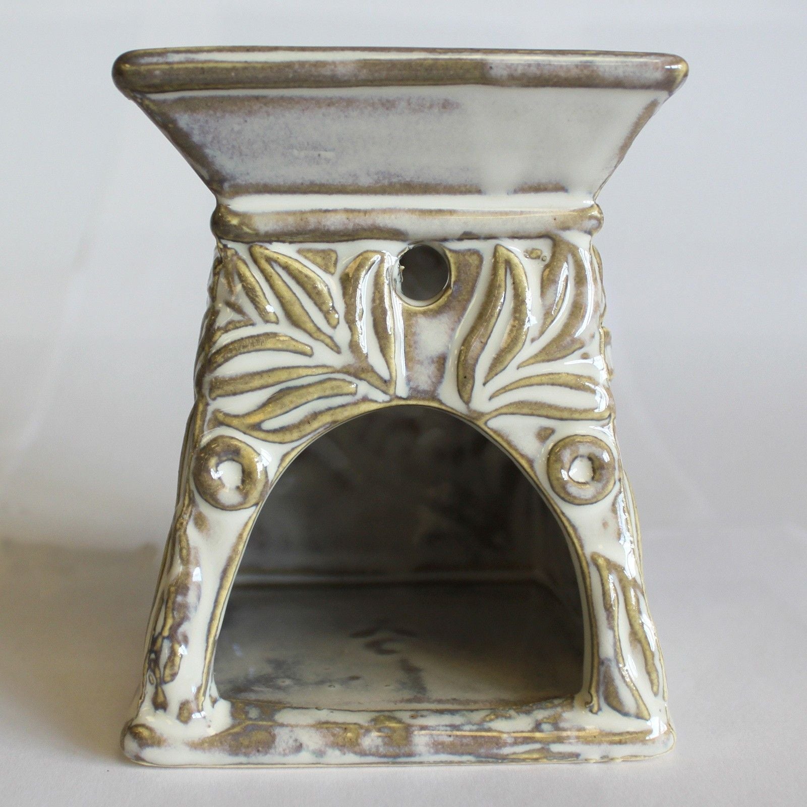 Ceramic oil burner with decorative patterns on a white background