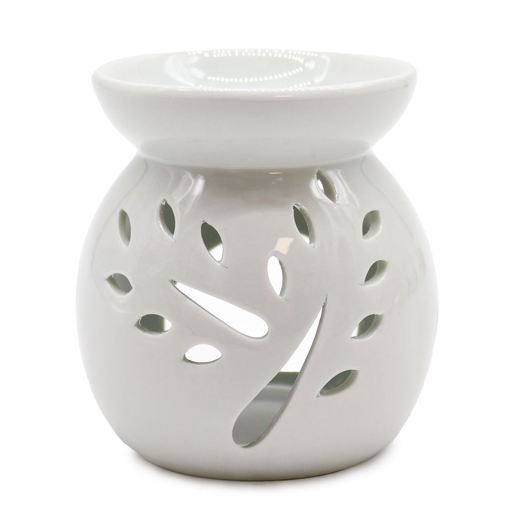 White ceramic oil burner with decorative cut-out design on a white background