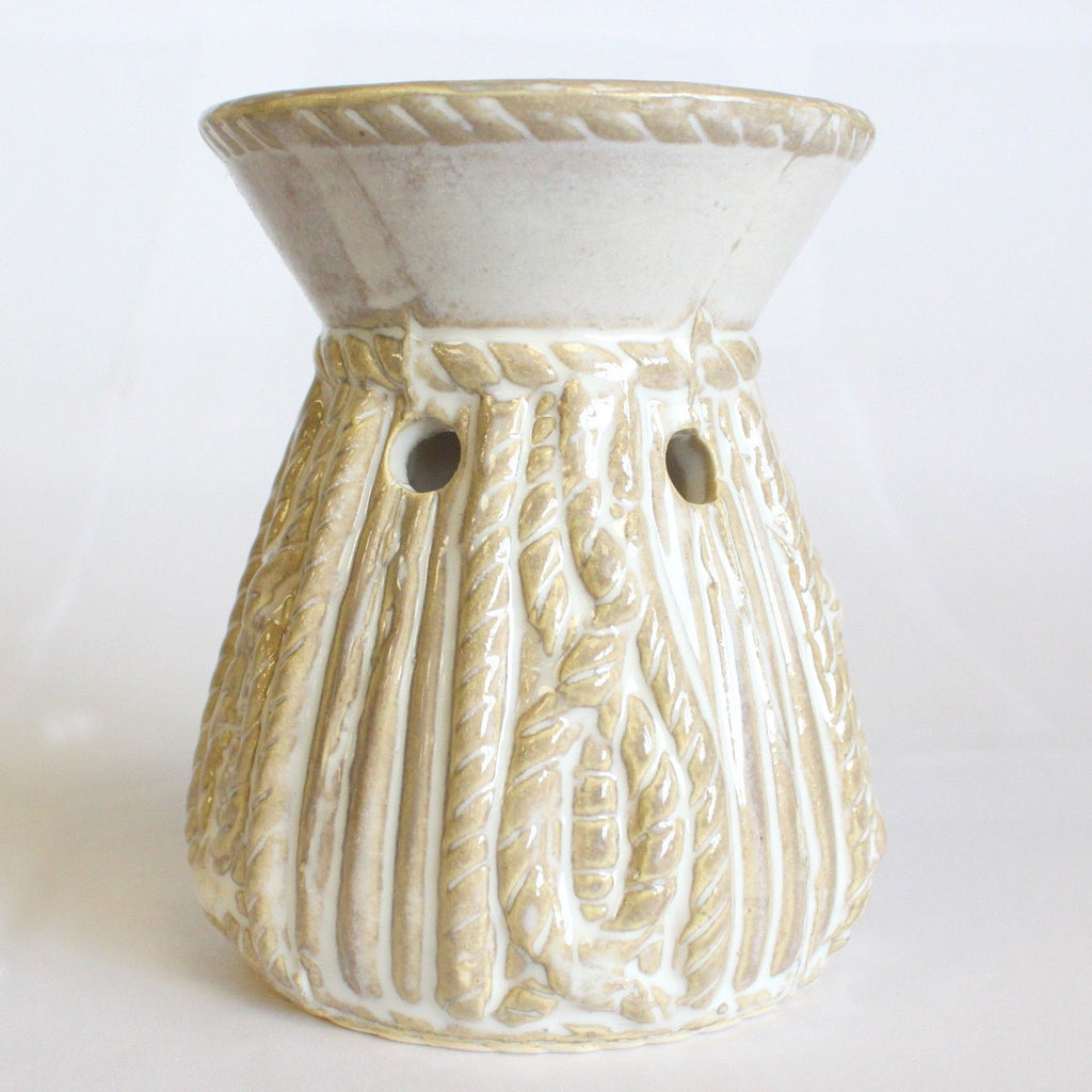White ceramic oil burner with a rope textured design on a white background