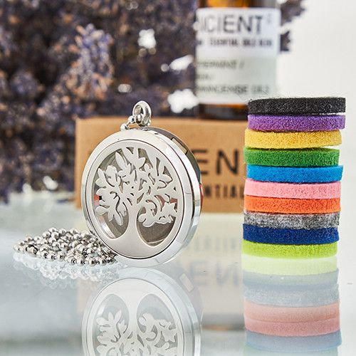 Silver tree-shaped locket on a reflective surface.